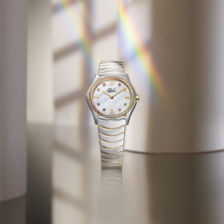La Sport Classic Gemstones 29 mm Édition Limitée célèbre la dimension esthétique d'Ebel avec une lunette sertie de pierres multicolores en dégradé arc-en-ciel et un cadran en nacre lumineuse, rehaussé du logo originel de 1911. Également proposée en 24 et 33 mm, elle conjugue couleur, lumière et élégance dans les lignes architecturales emblématiques de la collection.