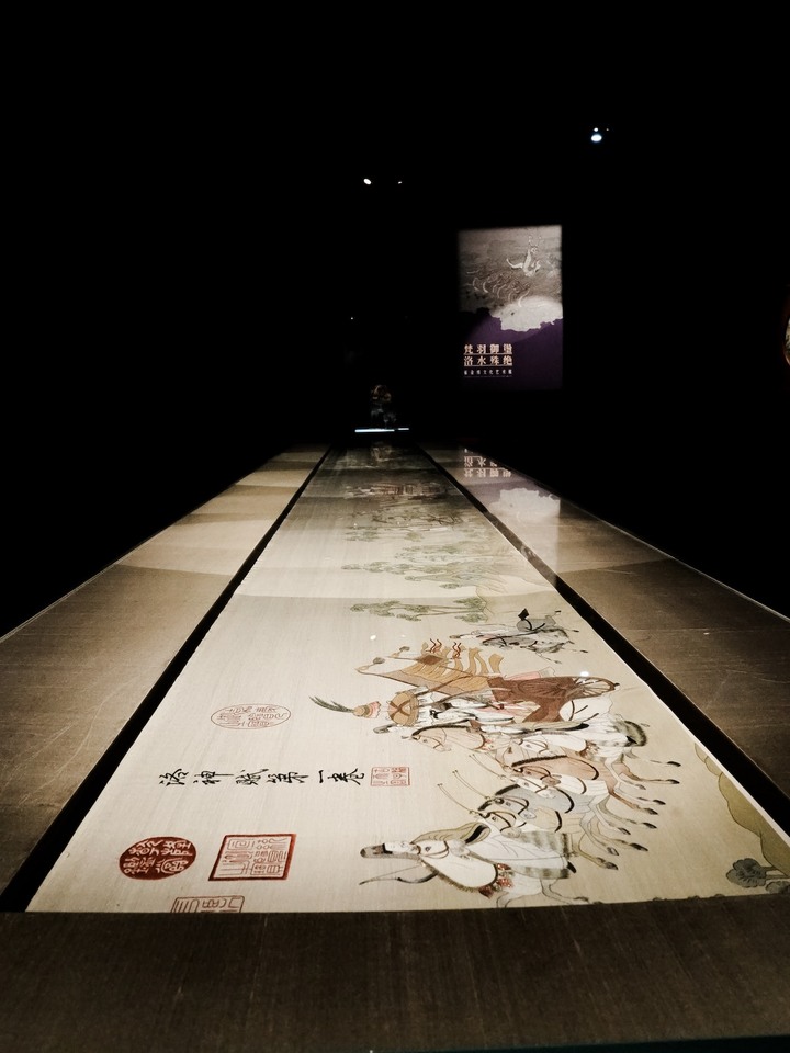 Inspirée par un poème du 3ème siècle et un tableau du siècle suivant, Wang Limin souhaitait écrire un nouveau chapitre célébrant le temps-rivière, l'amour éternel, l'aspiration à l'immortalité, et son propre art, tissé dans le silence et la rigueur. Au centre du modèle, les heures s'affichent sur un cadran en jade impérial clair, animé par deux aiguilles en or rouge. Autour, un anneau en rotation (30 secondes) en nacre micro-peinte évoque l'eau et le temps, alors qu'une carpe s'anime à la demande.